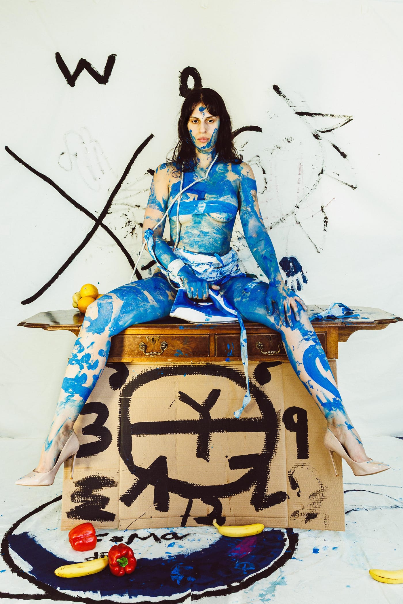 Painted figure seated on a decorated plinth