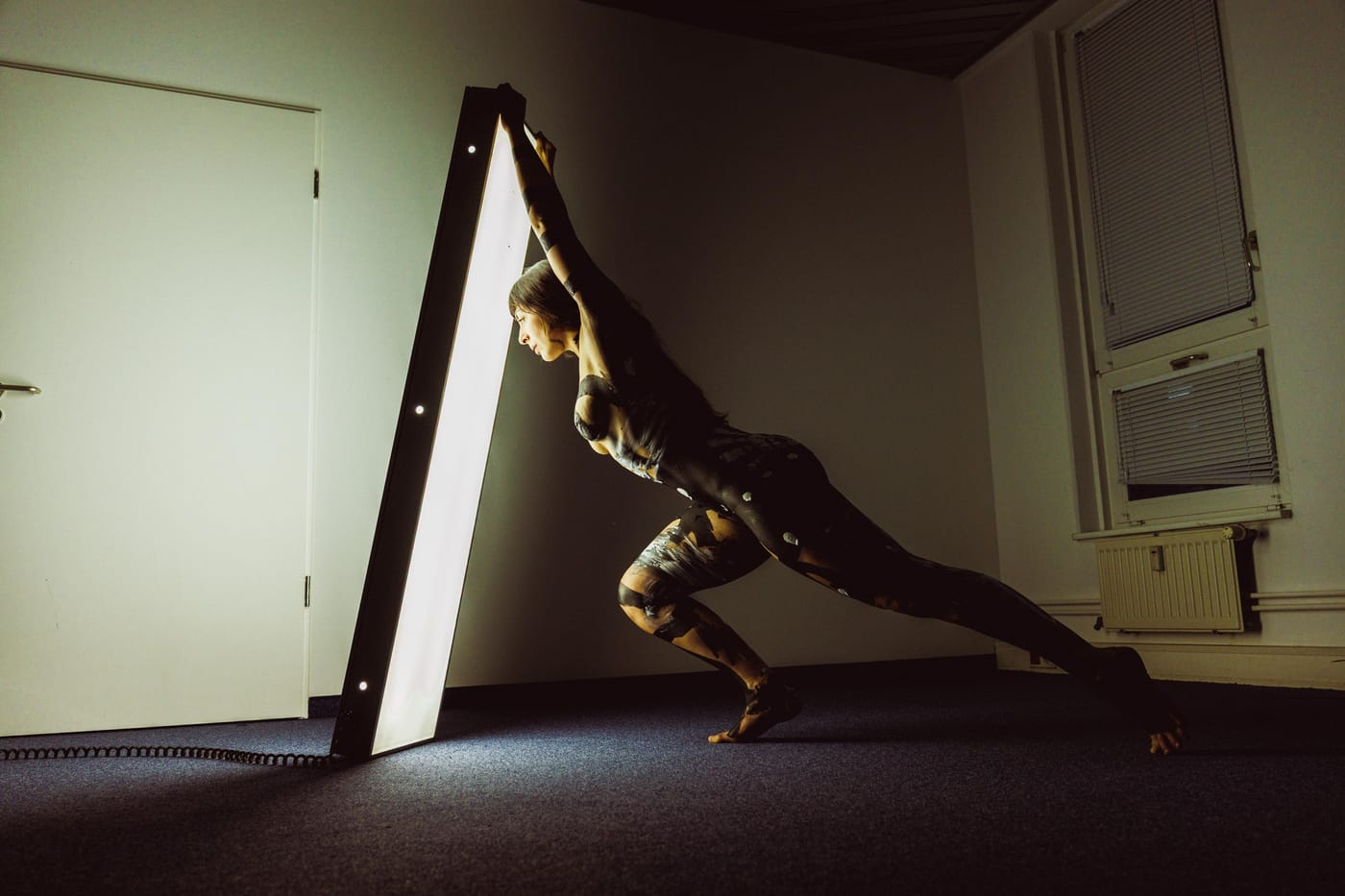 Figure balanced against a green wall