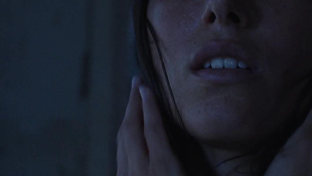 Close detail of a face and a hand at the throat