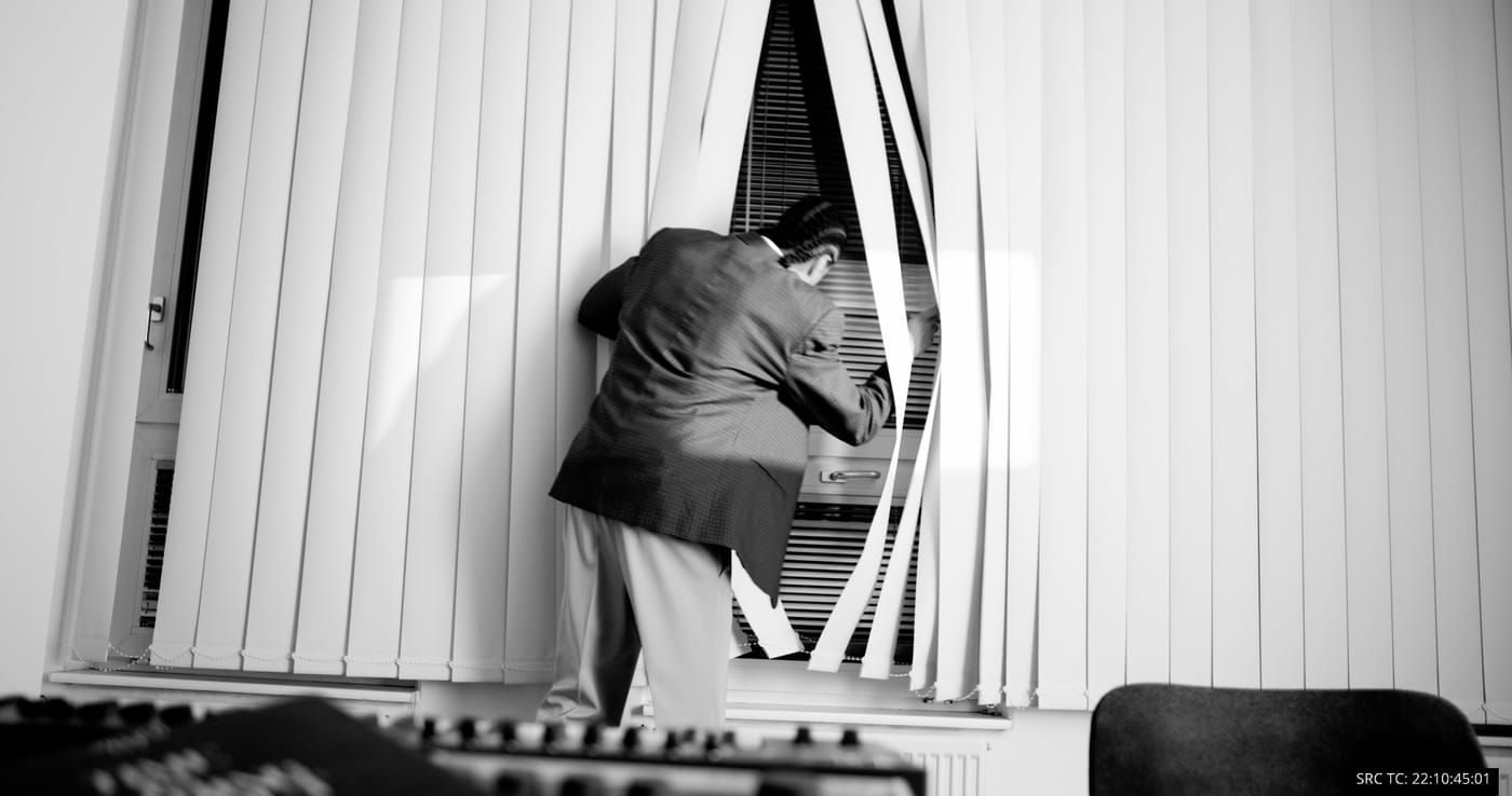Silhouette against a window of venetian blinds