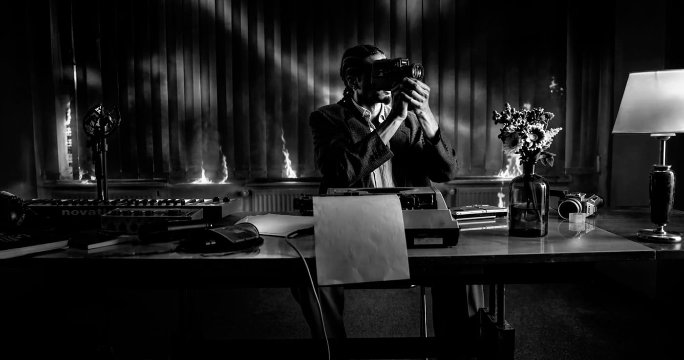 A desk lamp and a seated figure in shadow